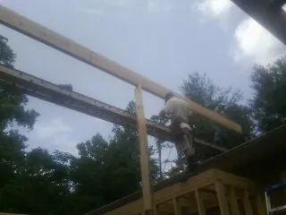 Carpenter setting a ridge beam over a new addition frame — Ice Dam Removal by Roofing Brothers in Crawfordville