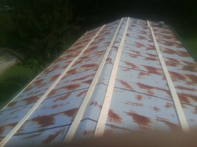 Rusted metal roof panels with new wood purlins before replacement — Storm Damage Roof Repair in Crawfordville by Roofing Brothers